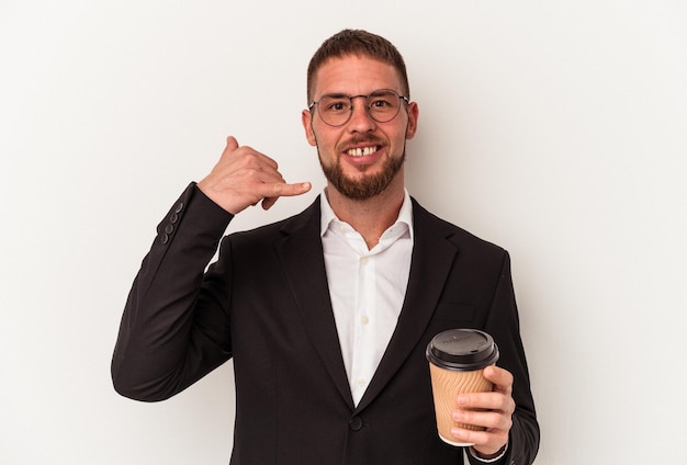 Jeune homme caucasien d'affaires tenant du café à emporter isolé sur fond blanc montrant un geste d'appel de téléphone portable avec les doigts.
