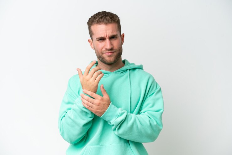 Photo un jeune homme caucasien beau isolé sur un fond blanc souffrant de douleurs aux mains
