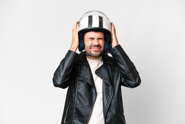 Jeune homme caucasien avec un casque de moto sur fond blanc isolé frustré et couvrant les oreilles