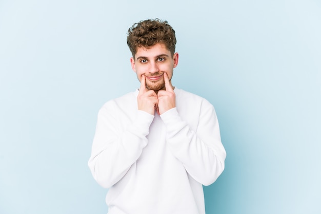 Jeune homme caucasien cheveux bouclés blonds doutant entre deux options.