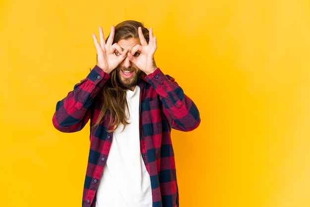 Jeune homme caucasien cheveux longs isolé exprimant des émotions