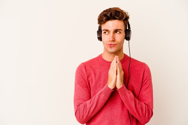 Jeune homme caucasien, écouter de la musique sur blanc, faire un plan à l'esprit, mettre en place une idée.