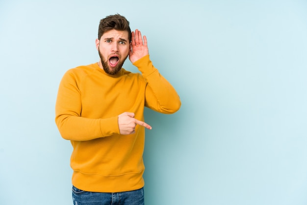 Jeune homme caucasien essayant d'écouter un commérage.