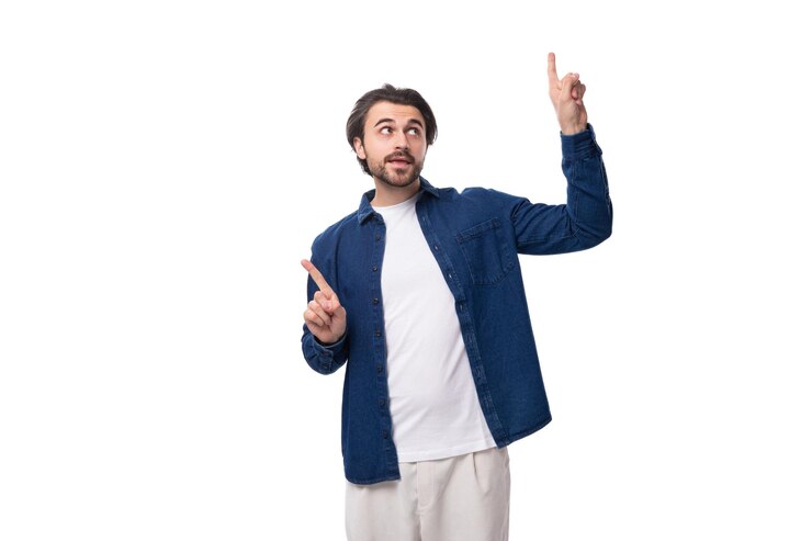Un jeune homme caucasien intelligent et beau aux cheveux noirs vêtu d'une chemise bleue est inspiré par une idée