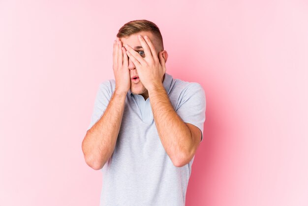 Jeune homme caucasien isolé cligner des yeux effrayé et nerveux.