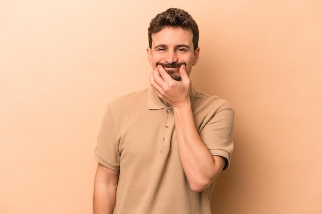 Jeune homme caucasien isolé sur fond beige doutant entre deux options.