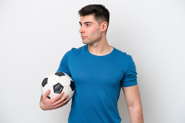 Jeune homme caucasien isolé sur fond blanc avec ballon de foot