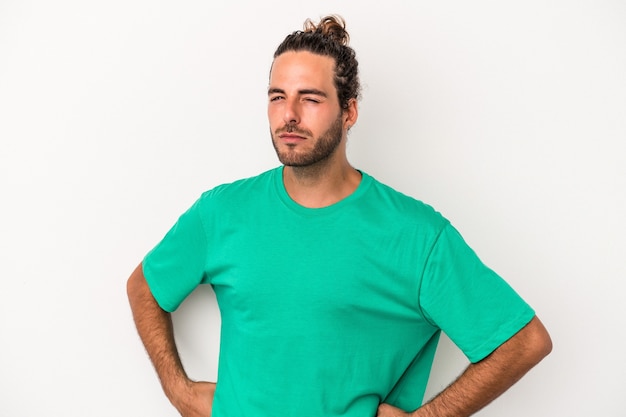 Photo jeune homme caucasien isolé sur fond blanc, fronçant les sourcils de mécontentement, garde les bras croisés.