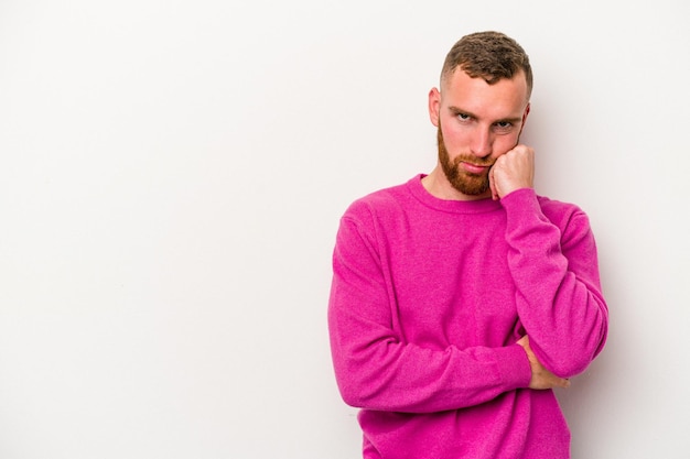 Jeune homme caucasien isolé sur fond blanc qui se sent triste et pensif, regardant l'espace de copie.