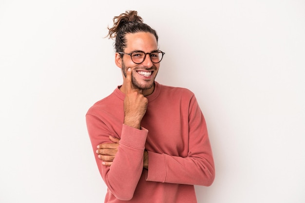 Jeune homme caucasien isolé sur fond blanc souriant heureux et confiant, touchant le menton avec la main.