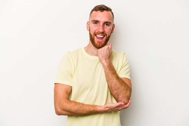 Jeune homme caucasien isolé sur fond blanc souriant heureux et confiant, touchant le menton avec la main.