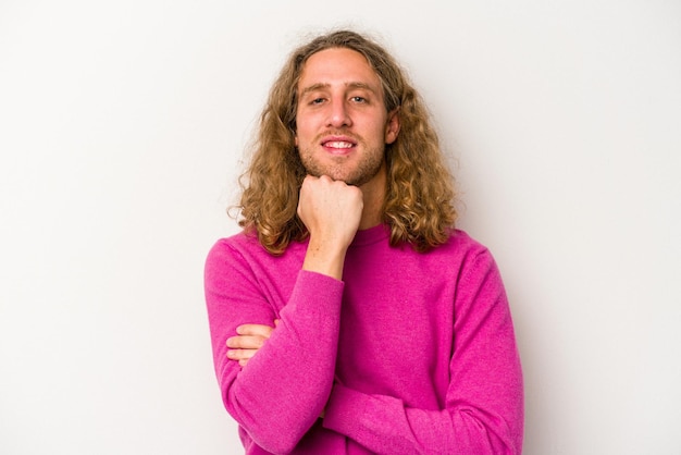 Jeune homme caucasien isolé sur fond blanc souriant heureux et confiant touchant le menton avec la main