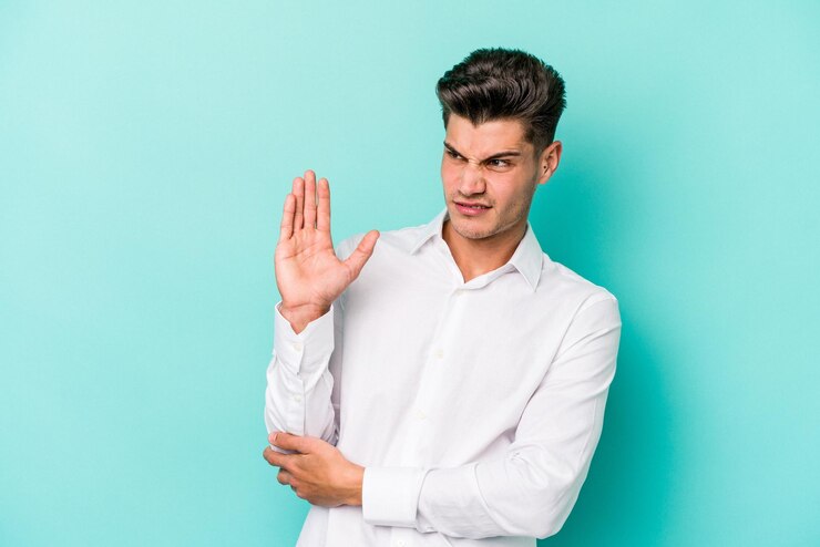 Photo jeune homme caucasien isolé sur fond bleu confus se sent douteux et incertain