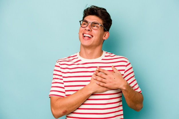 Jeune homme caucasien isolé sur fond bleu a une expression amicale en appuyant sur la paume contre la poitrine Concept d'amour