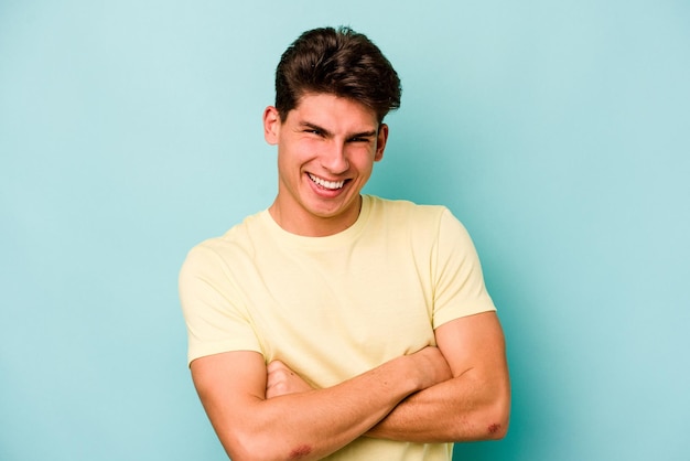 Jeune homme caucasien isolé sur fond bleu rire et s'amuser