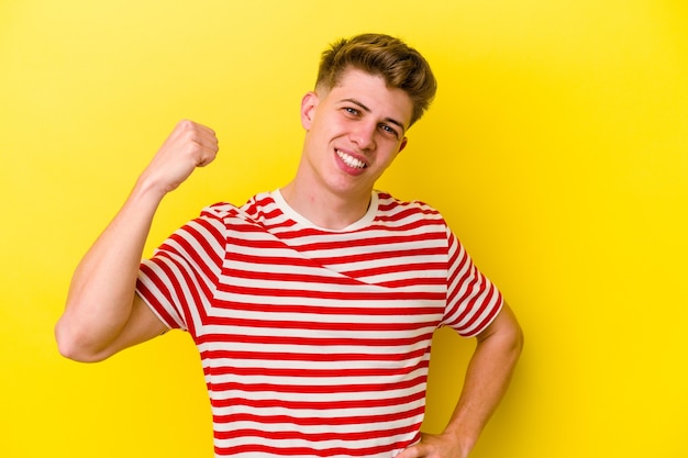 Jeune homme caucasien isolé sur fond jaune applaudissant insouciant et excité. Concept de victoire.