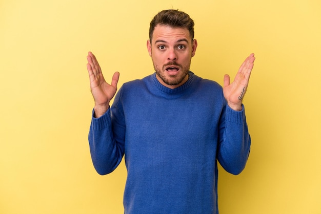 Jeune homme caucasien isolé sur fond jaune ayant un concept d'inspiration idée