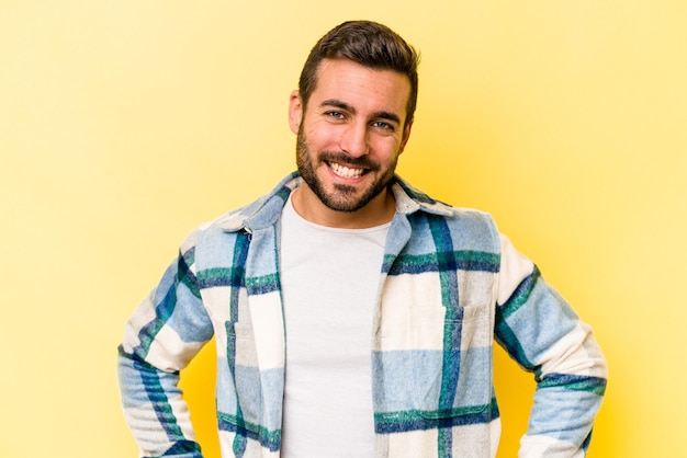 Jeune homme caucasien isolé sur fond jaune heureux souriant et joyeux