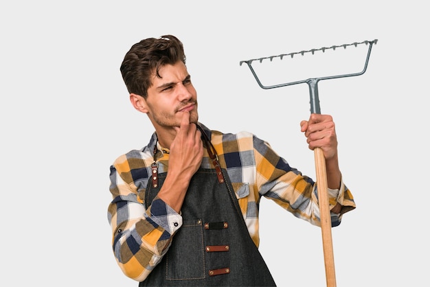 Jeune homme caucasien jardinier tenant une plante isolée sur fond blanc