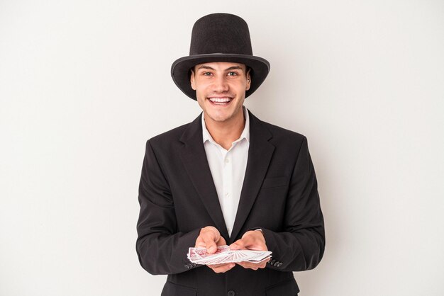 Photo jeune homme caucasien magicien tenant une carte magique isolée sur fond blanc