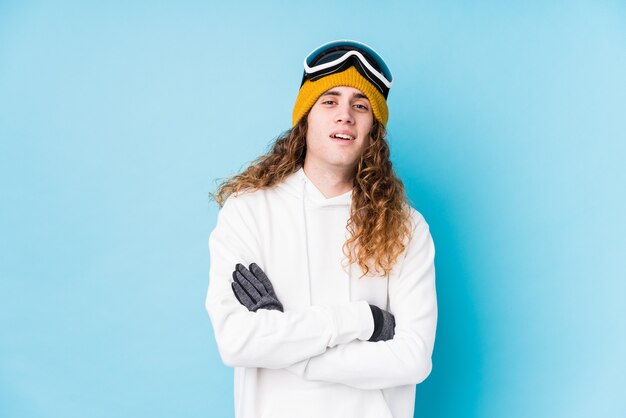 Jeune homme caucasien portant un vêtement de ski isolé en riant et en s'amusant.