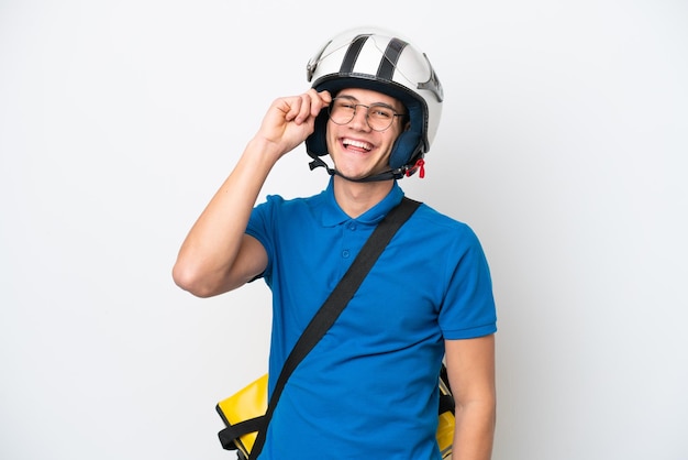 Jeune homme caucasien avec sac à dos thermique isolé sur fond blanc avec des lunettes et heureux