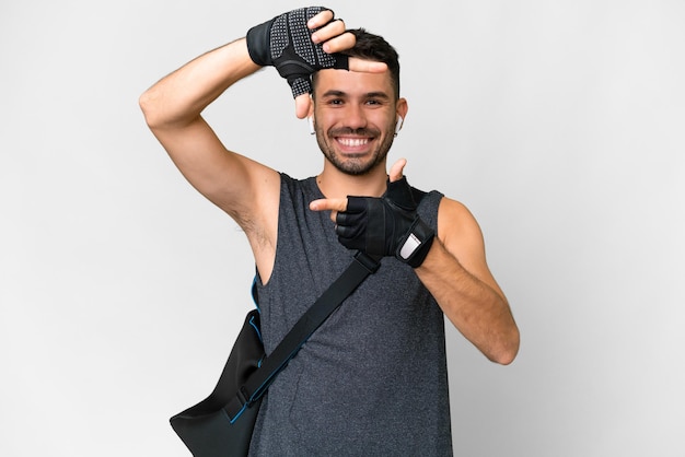 Jeune homme caucasien sport avec sac de sport sur fond blanc isolé se concentrant sur le visage Symbole de cadrage