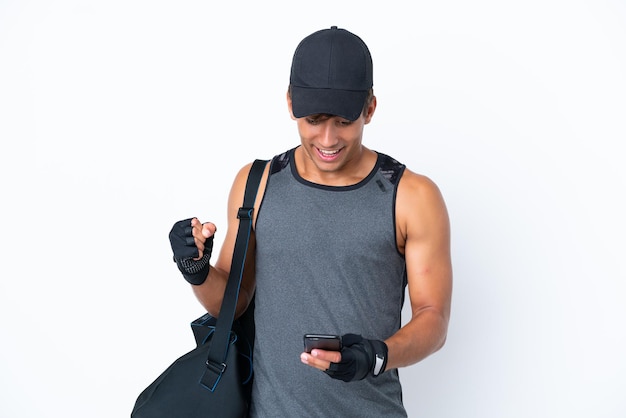 Jeune homme caucasien de sport avec sac de sport isolé sur fond blanc surpris et envoyant un message