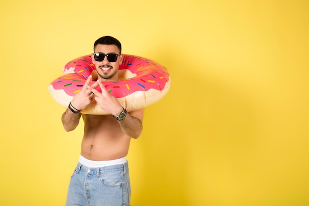 Jeune homme caucasien tenant un beignet gonflable