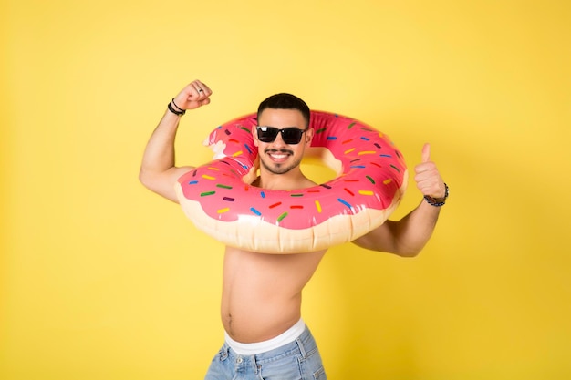 Jeune homme caucasien tenant un beignet gonflable