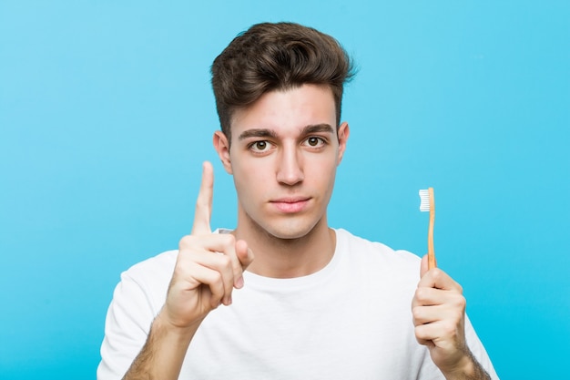 Jeune homme caucasien tenant une brosse à dents Jeune femme indienne portant un pyjama et un masque de sommeil