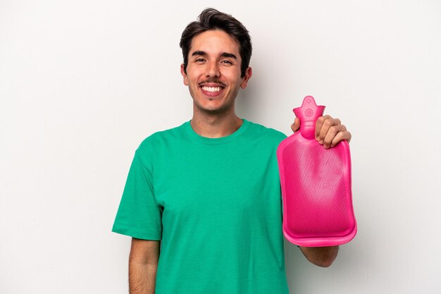 Jeune homme caucasien tenant un sac d'eau isolé sur fond blanc heureux, souriant et joyeux.