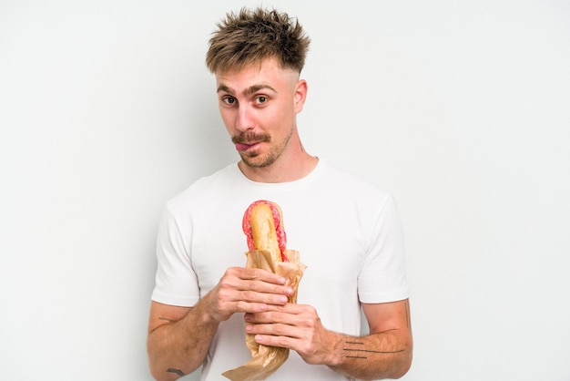 Jeune homme caucasien tenant un sandwich isolé sur fond blanc