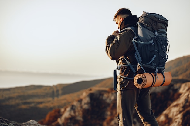 Jeune homme caucasien voyageur avec gros sac à dos de randonnée dans les montagnes seules