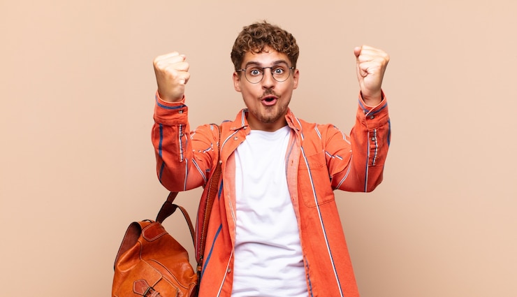 Photo jeune homme célébrant un succès incroyable comme un gagnant, l'air excité et heureux de dire prenez ça
