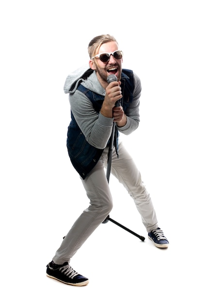 Jeune homme chantant avec microphone isolé sur blanc