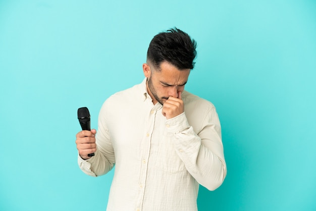 Jeune homme chanteur caucasien isolé sur fond bleu ayant des doutes