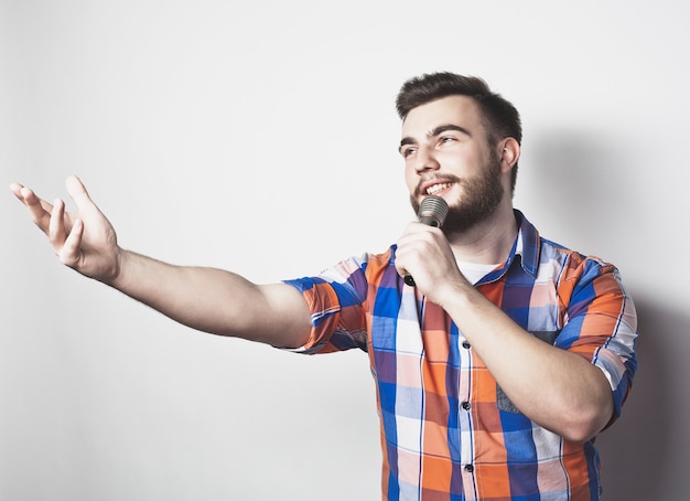 Photo jeune homme chanteur avec microphone sur fond gris