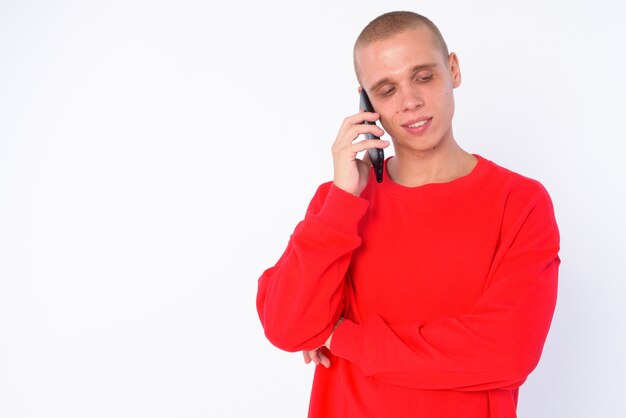 Jeune homme chauve isolé contre un mur blanc