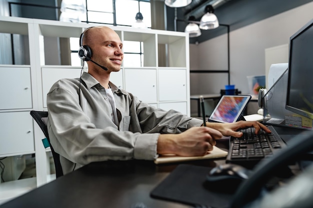 Photo jeune homme chauve travaillant dans un bureau de centre d'appels