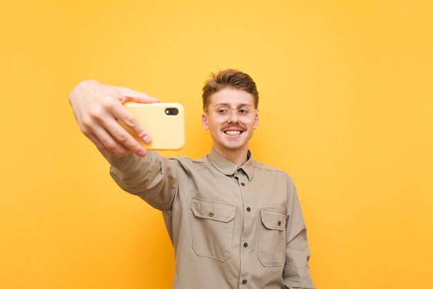 Jeune homme en chemise et lunettes isolés