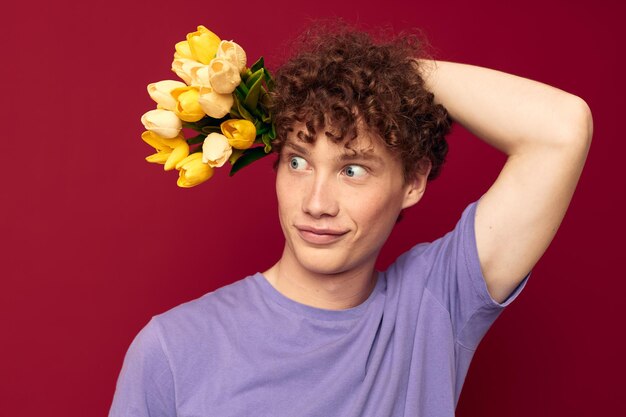 Un jeune homme cheveux roux en vêtements décontractés bouquet de fleurs cadeau fond isolé inchangé