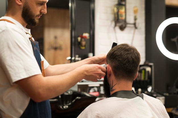 Jeune homme chez le coiffeur se faisant couper les cheveux