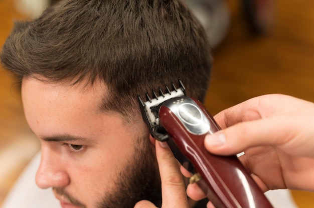 Jeune homme chez le coiffeur se faisant couper les cheveux