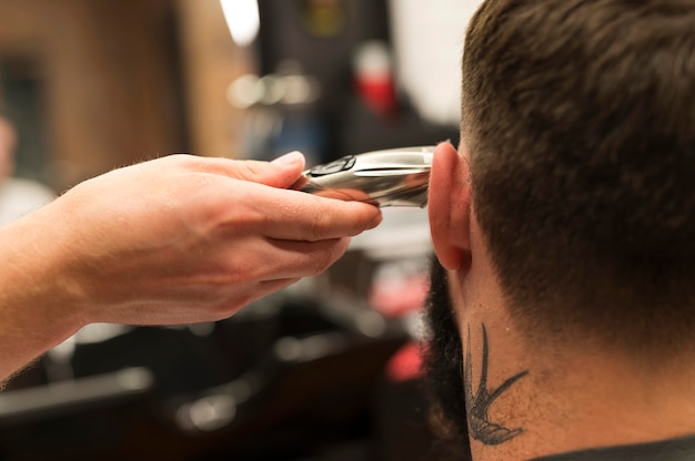 Jeune homme chez le coiffeur se faisant couper les cheveux