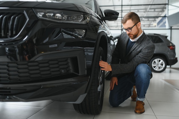 Jeune homme chez le concessionnaire automobile