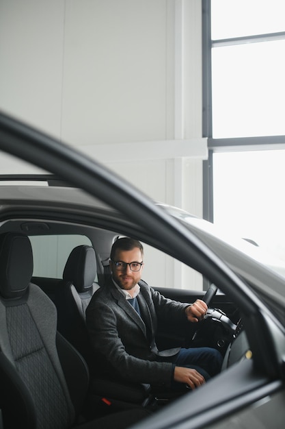 Jeune homme chez le concessionnaire automobile