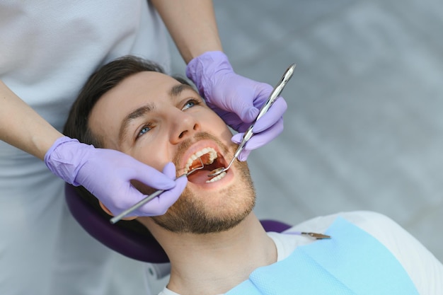 Jeune homme chez le dentiste Soins dentaires prenant soin des dents Photo avec espace de copie pour le fond