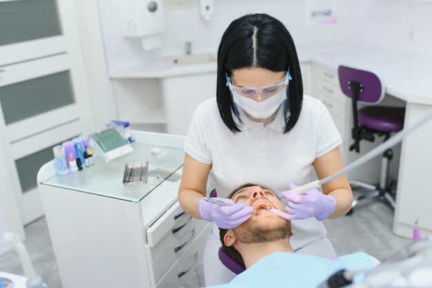 Jeune homme chez le dentiste Soins dentaires prenant soin des dents Photo avec espace de copie pour le fond