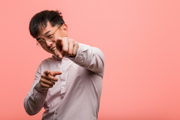 Jeune homme chinois gai et souriant pointant vers l'avant